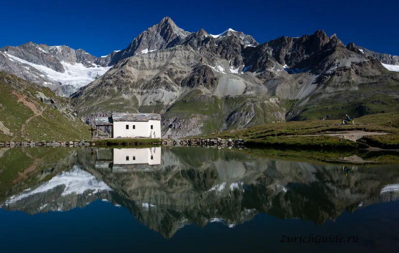 The chapel at Schwarzsee reflected in the lake below the Matterhorn